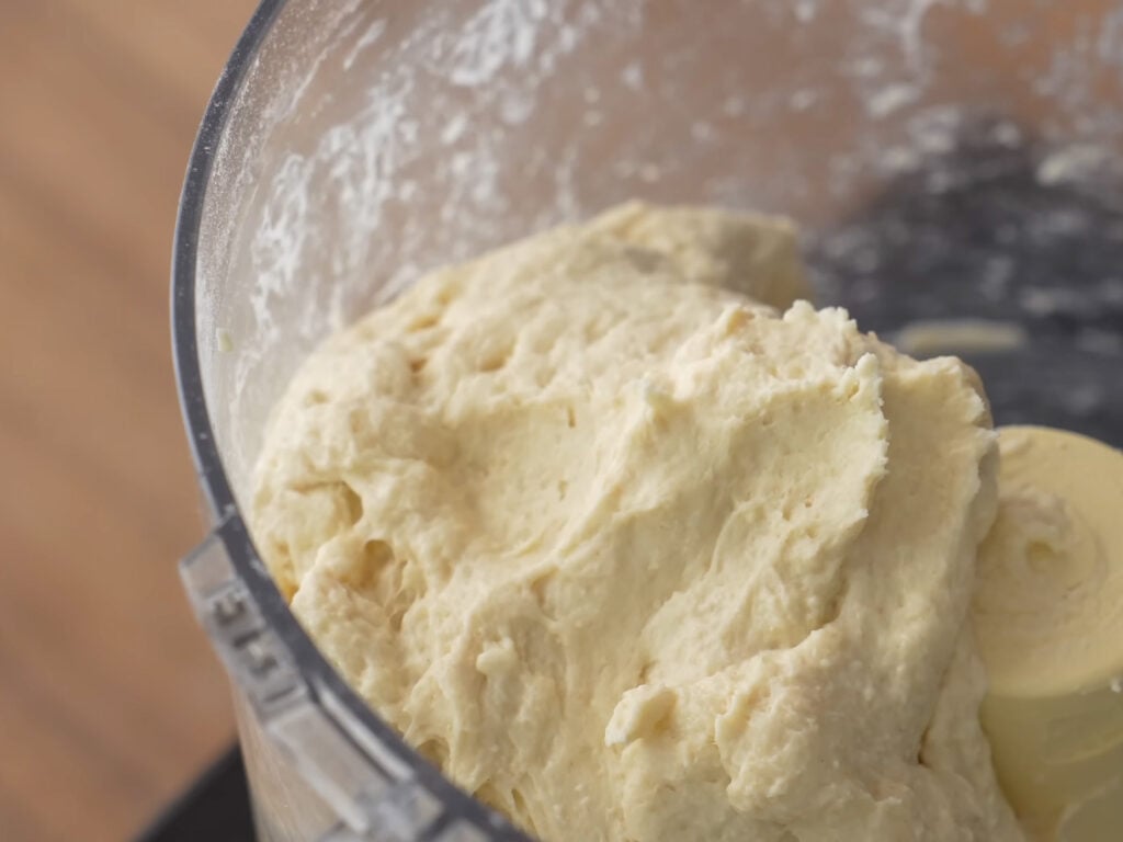 mixed pizza dough in jar of a food processor