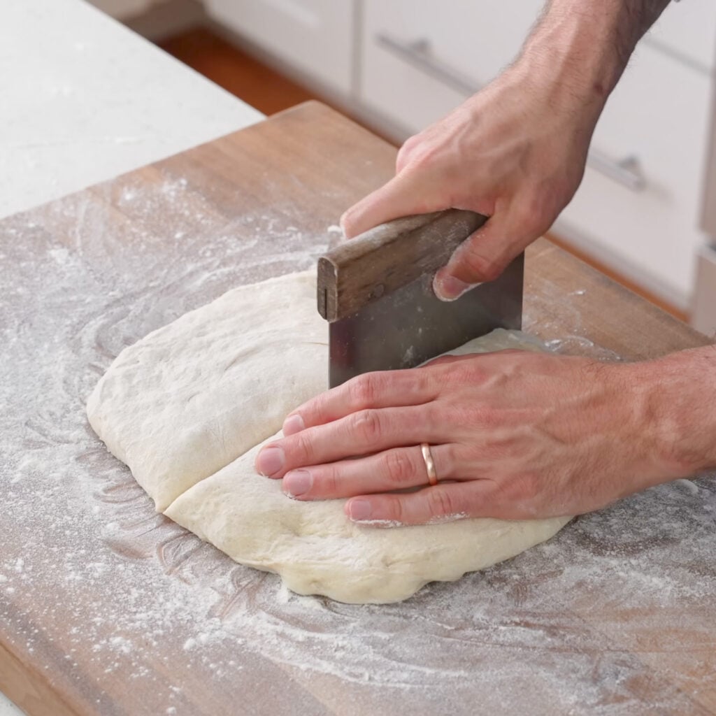 cutting square of bread dough in half