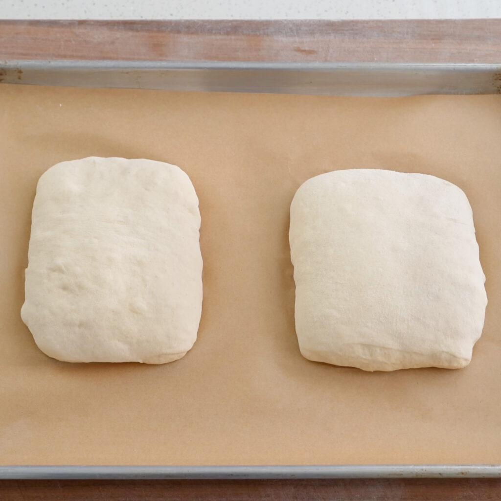 two bread dough sections shaped like rectangles sitting on parchment