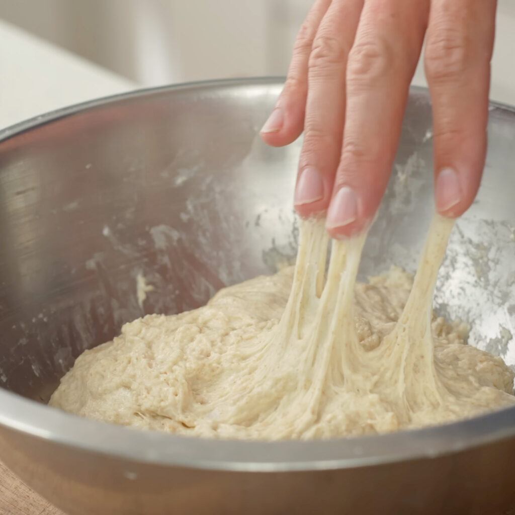 dough sticking to fingers as they pull away