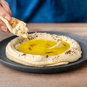 chickpea hummus with pita on a grey plate