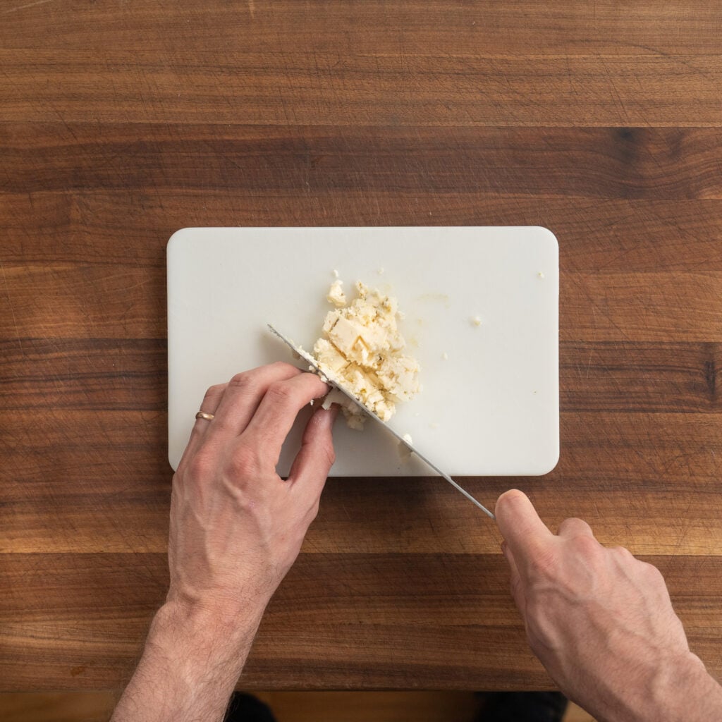 dicing blue cheese on a cutting board