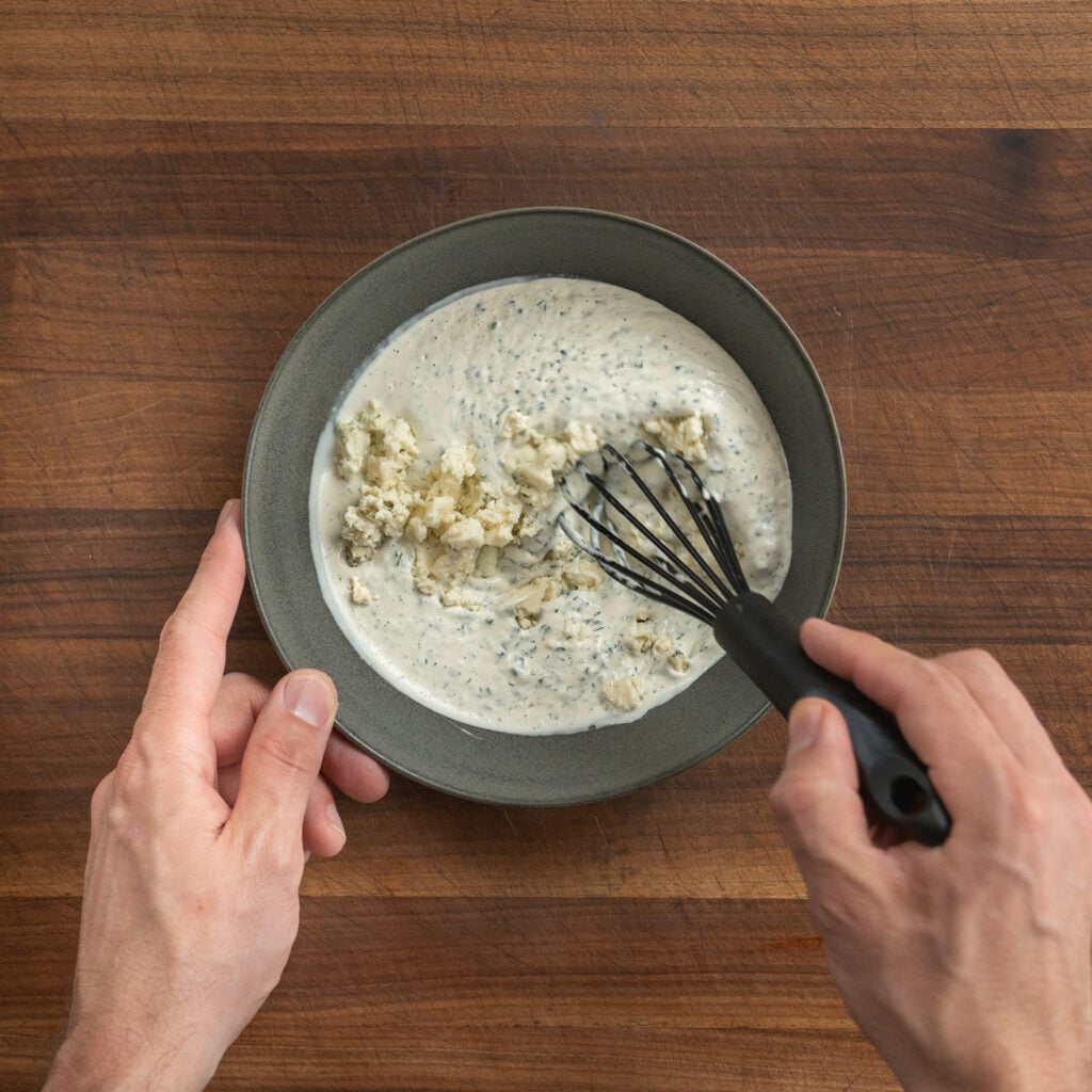 whisking blue cheese into dressing