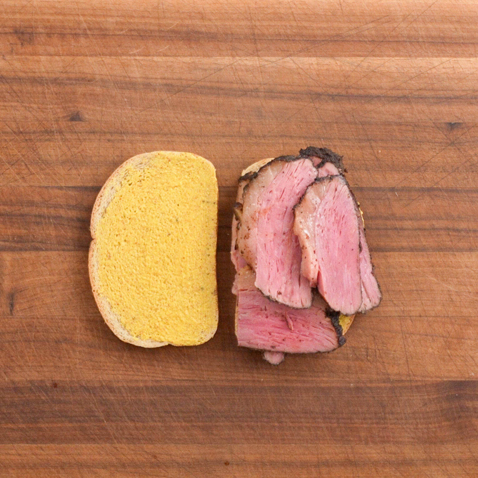 pastrami on rye sandwich on wooden cutting board
