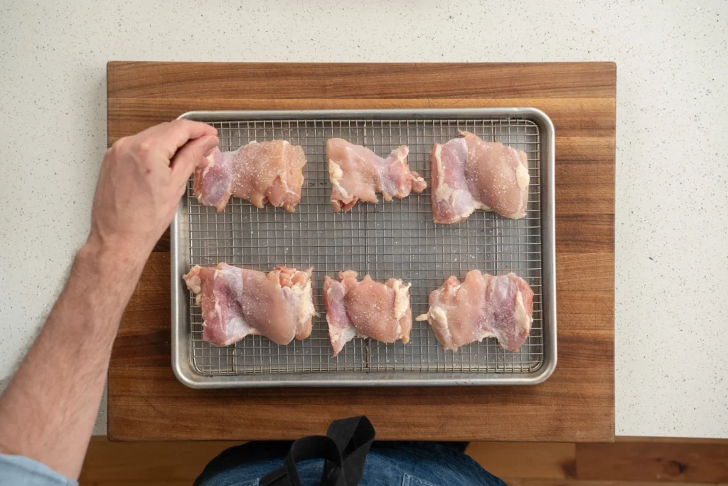 seasoning chicken thighs on wire rack