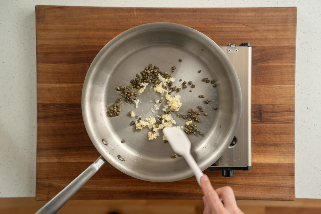 sautéing garlic and capers in a pan