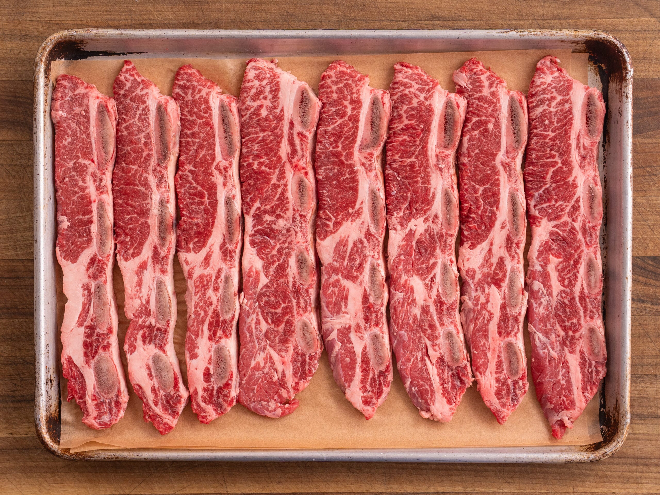 korean short ribs lined up on a silver sheet tray