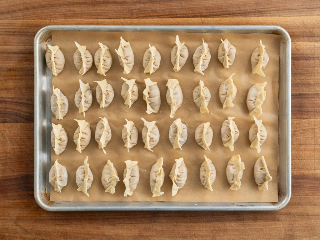 parchment lined sheet tray filled with 36 wontons