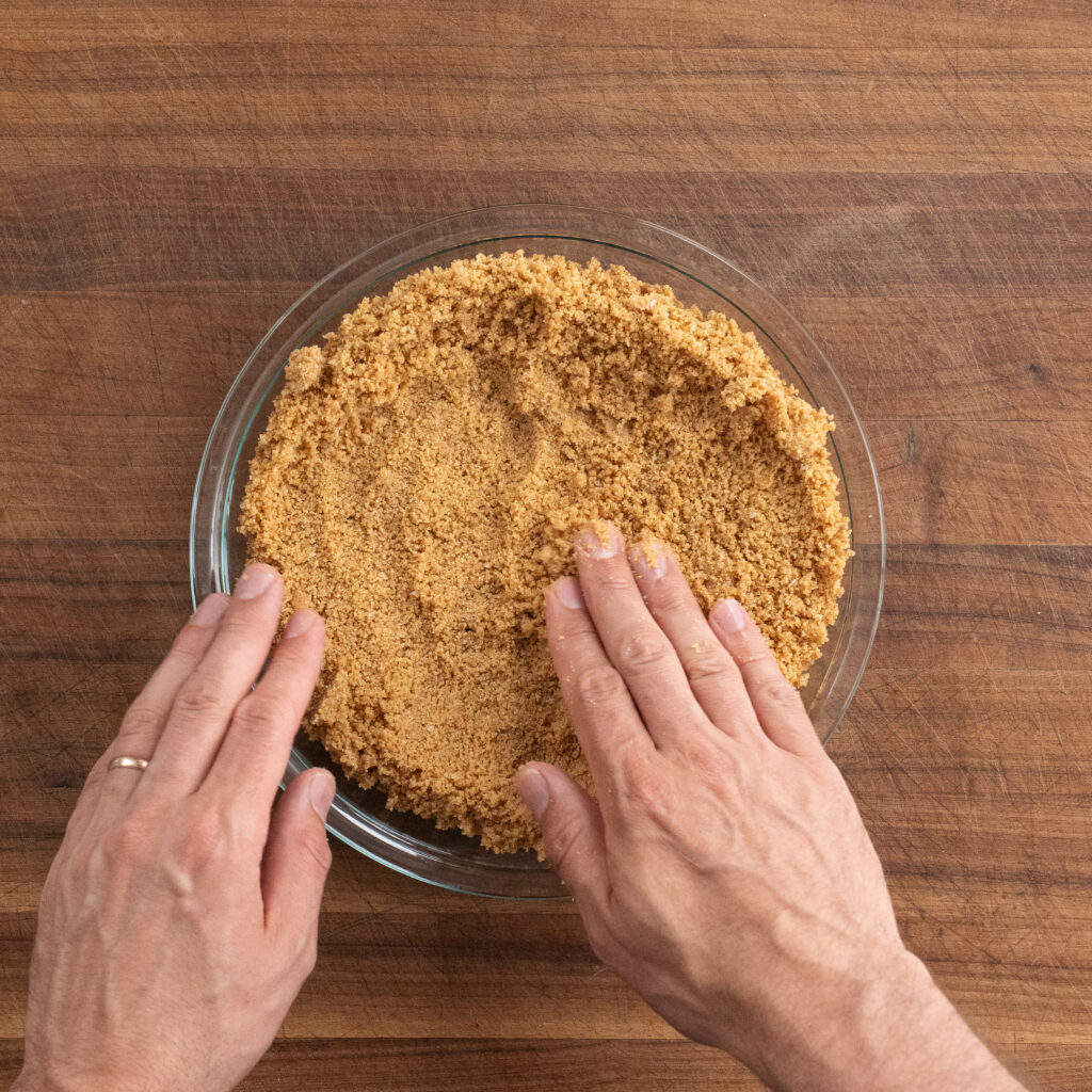 pressing graham cracker crust into pie plate