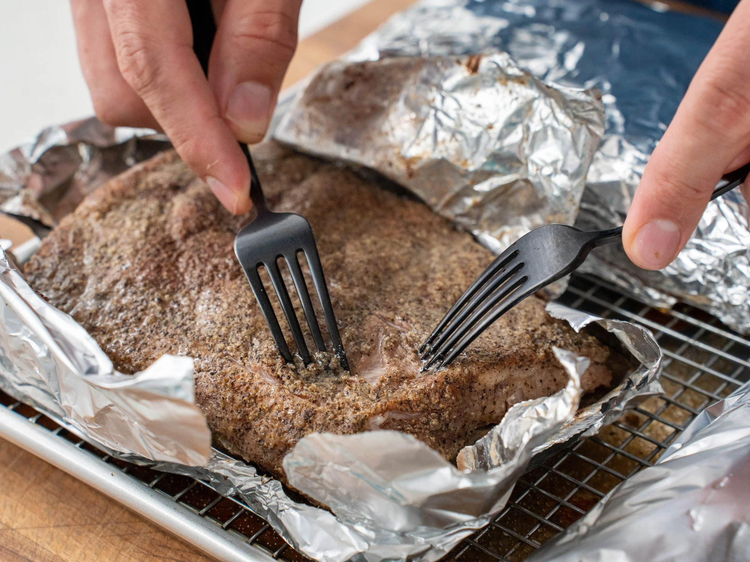 checking doneness of roast ribs with two black forks