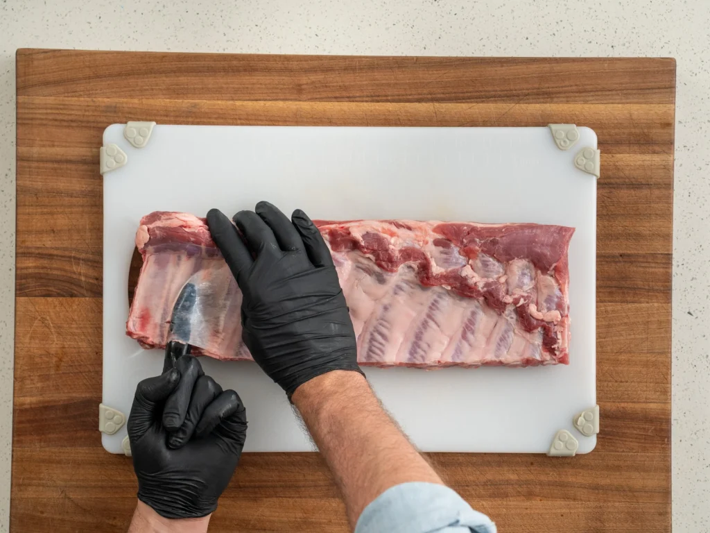black gloved finger under pork rib membrane