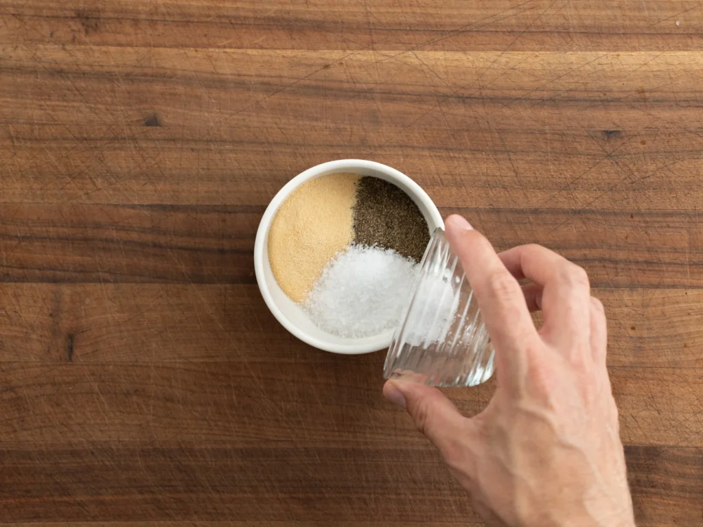 mixing salt pepper garlic powder in white container