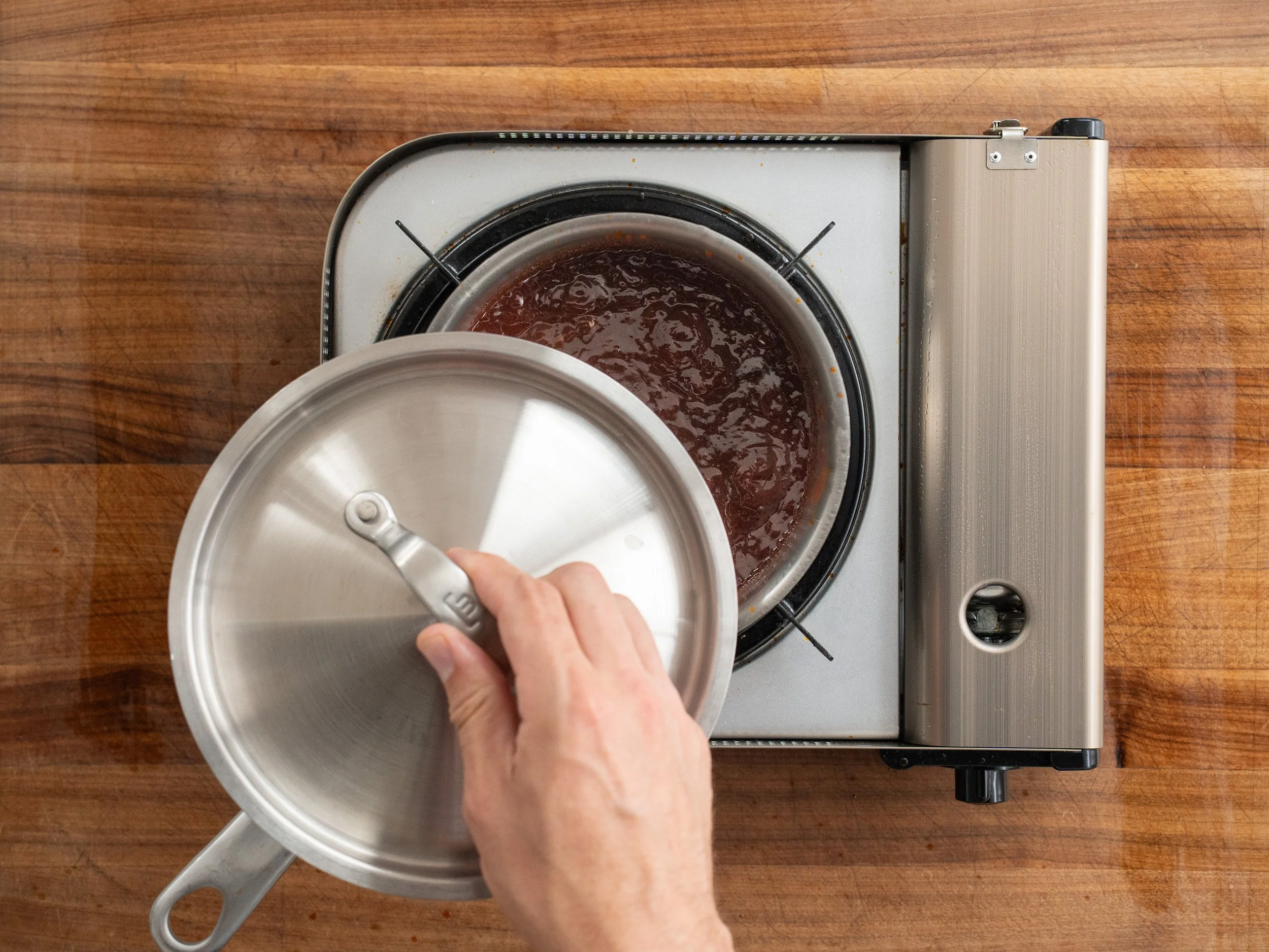 adding lid to simmering bbq sauce