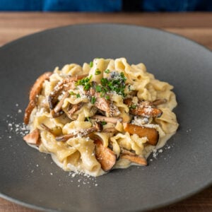 pasta with mushrooms on a black plate