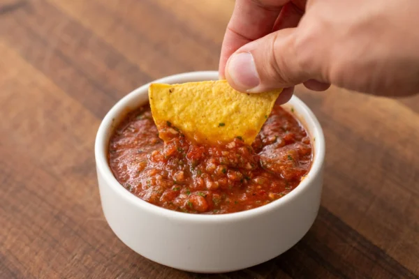 chip dipping into tomato salsa