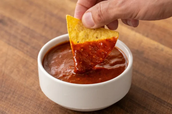 tortilla chip dipping into salsa taquera