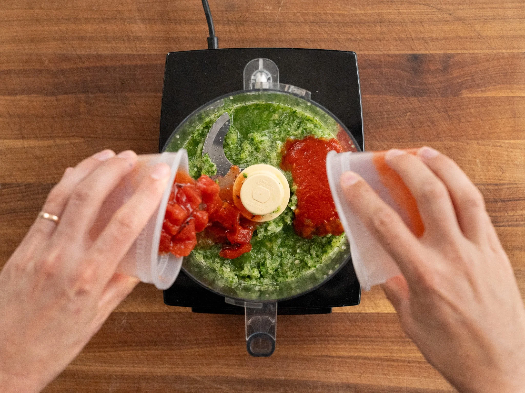 adding tomato to peppers and onions in food processor