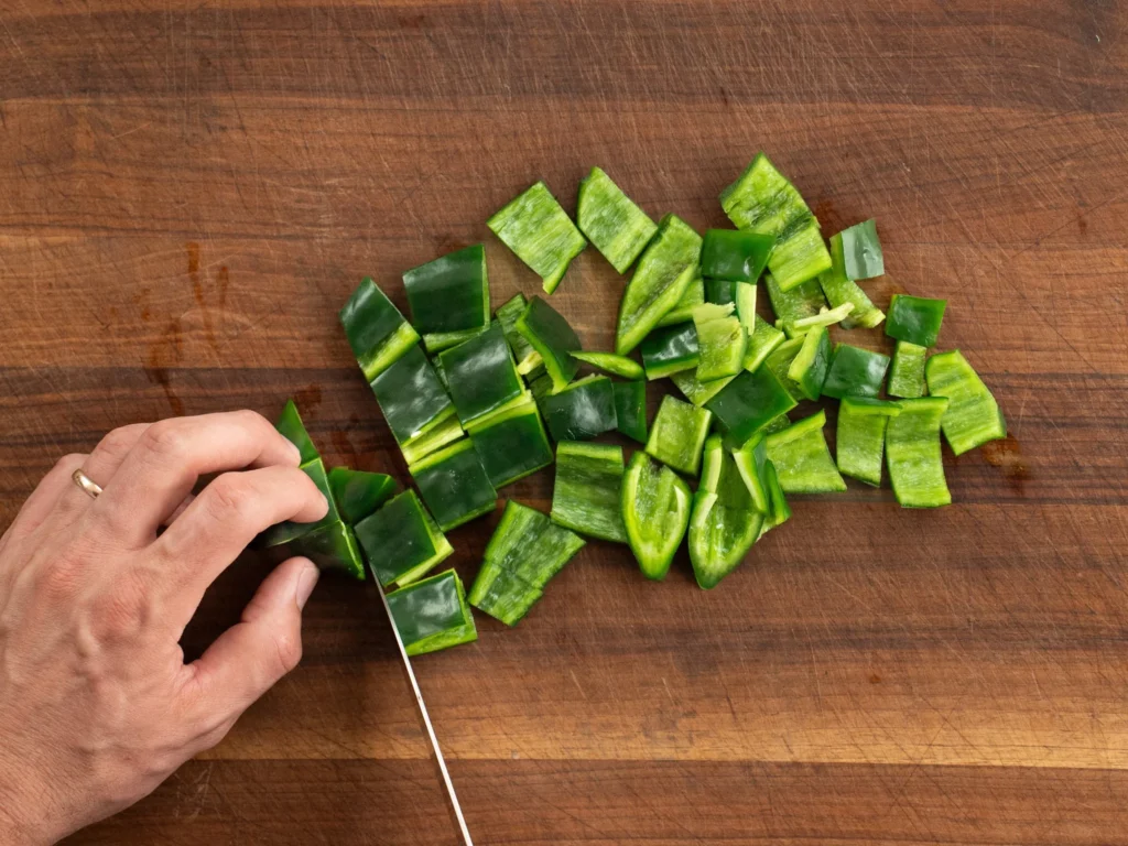 chopping poblano peppers on wood cutting board