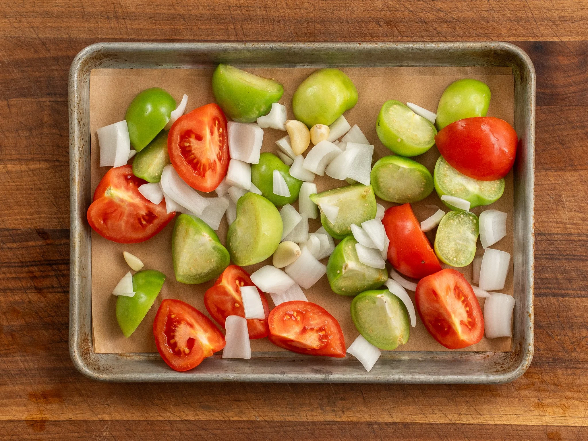 tomatoes tomatillos onion garlic on sheet pan