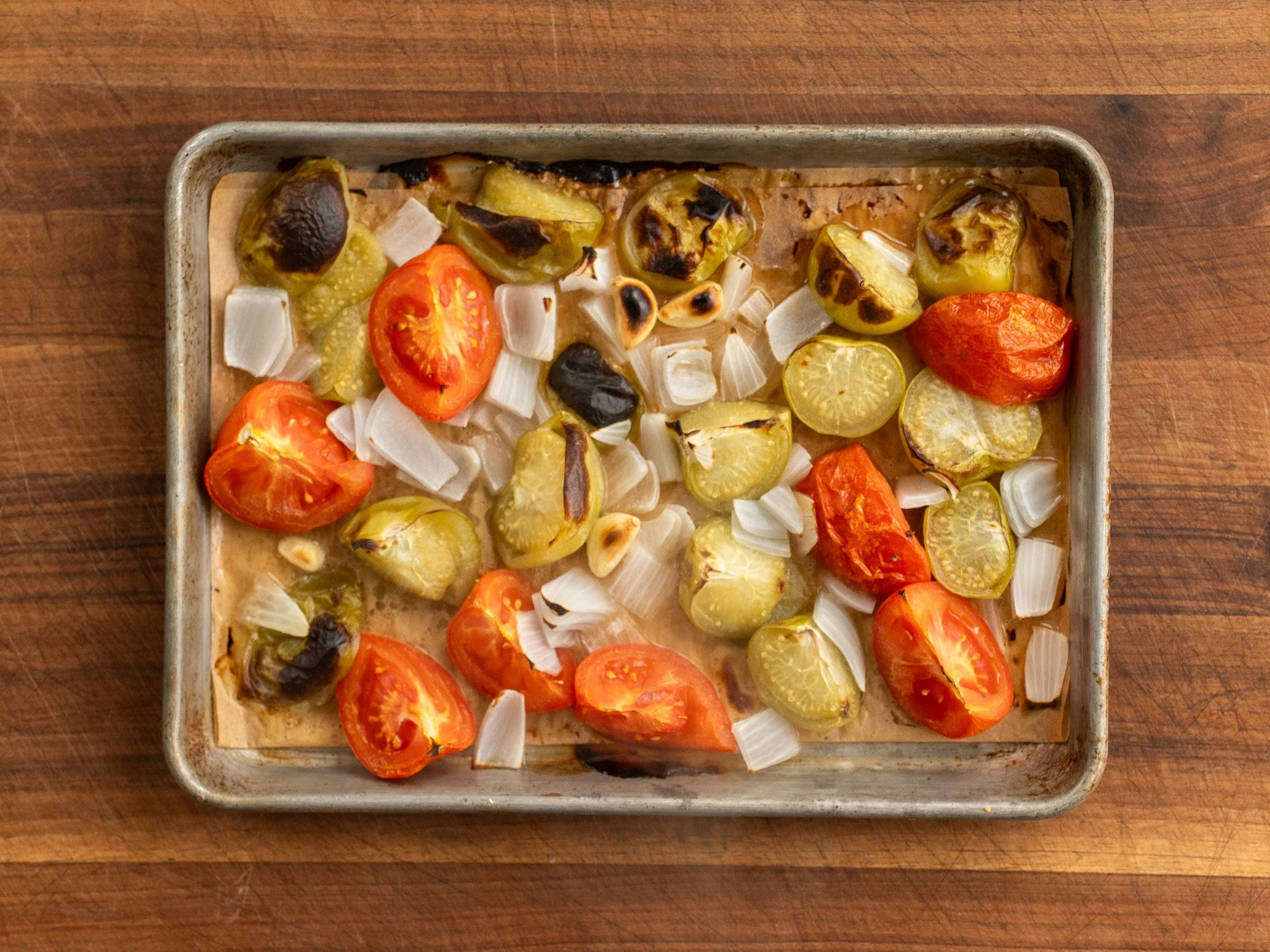 roasted tomatoes and tomatillos on sheet pan