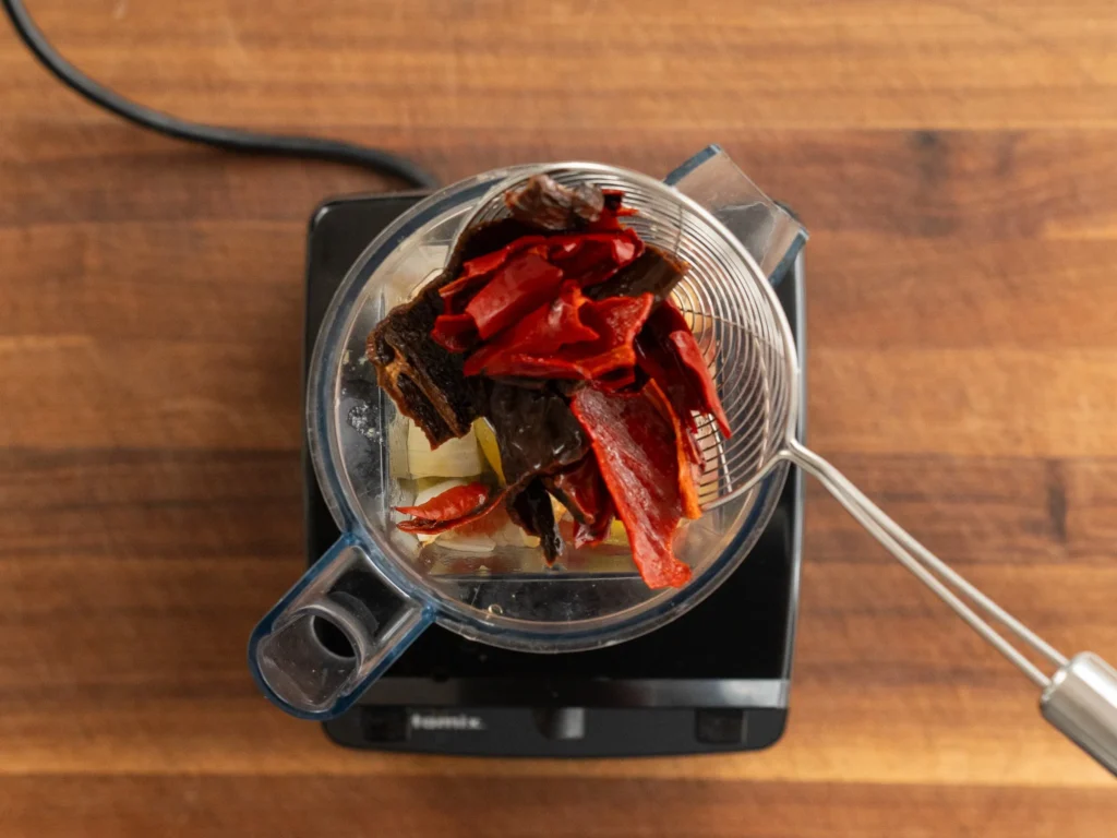adding dried chiles to blender jar using spicer