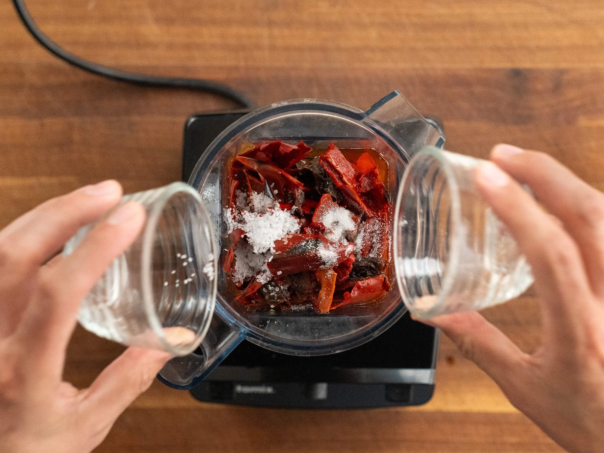 adding salt and sugar to blender jar with dried chiles 