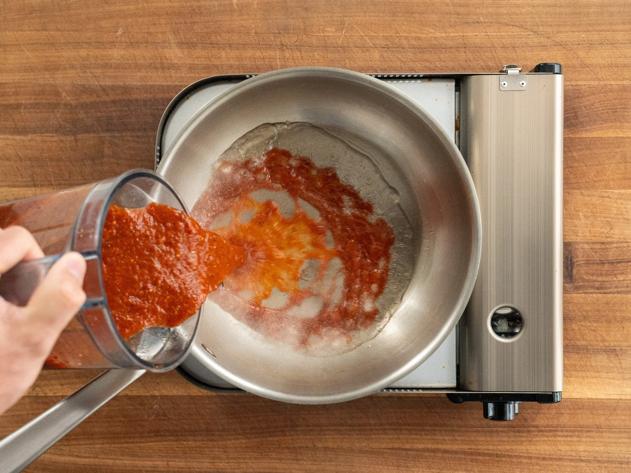 adding salsa taquera to sauce pan with oil