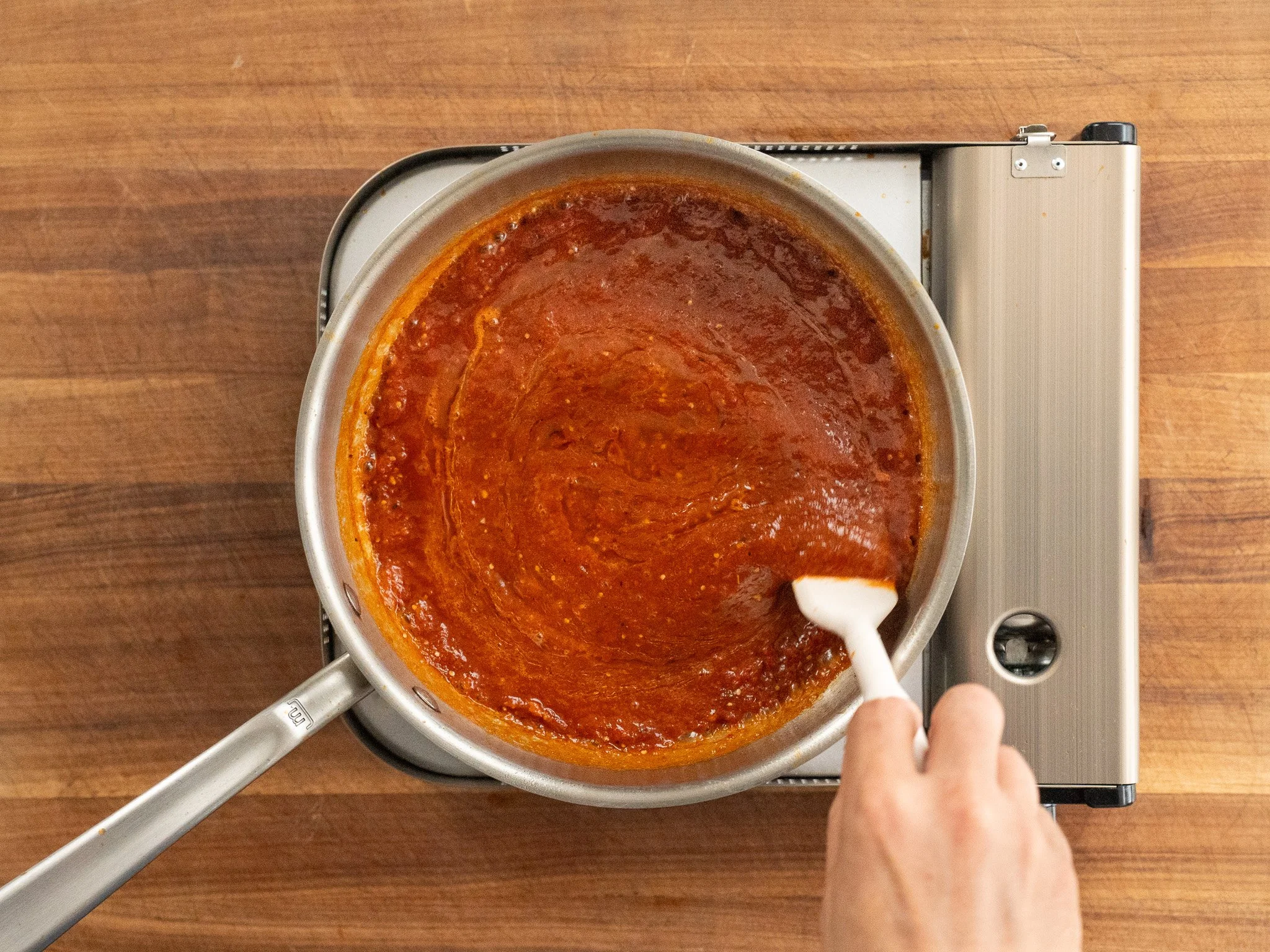 frying salsa taquera in sauce pan and stirring with white spatula