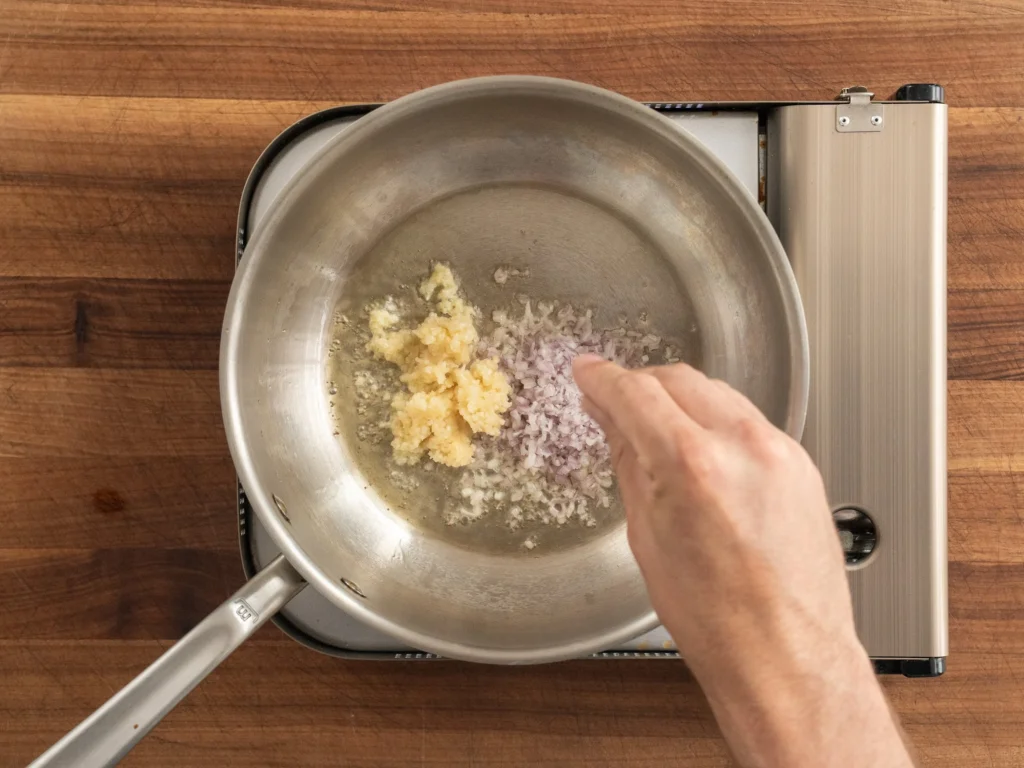 adding salt to pan of garlic and shallot