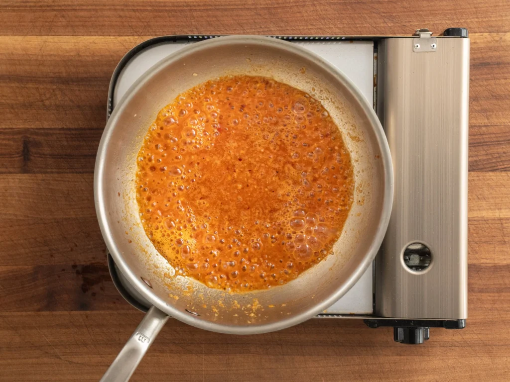 silver pot of simmering white wine sauce