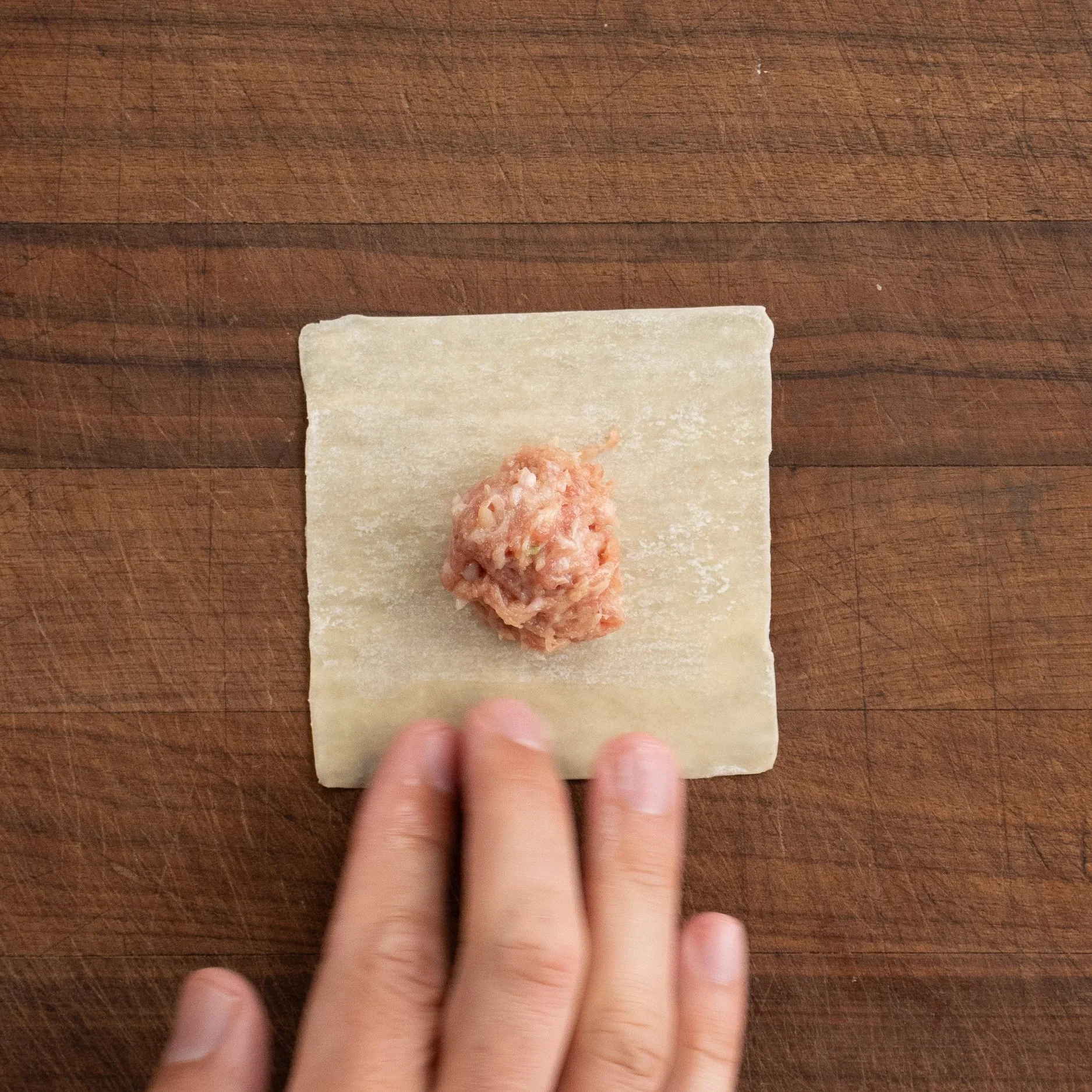 wonton wrapper with ball of wonton filling in center