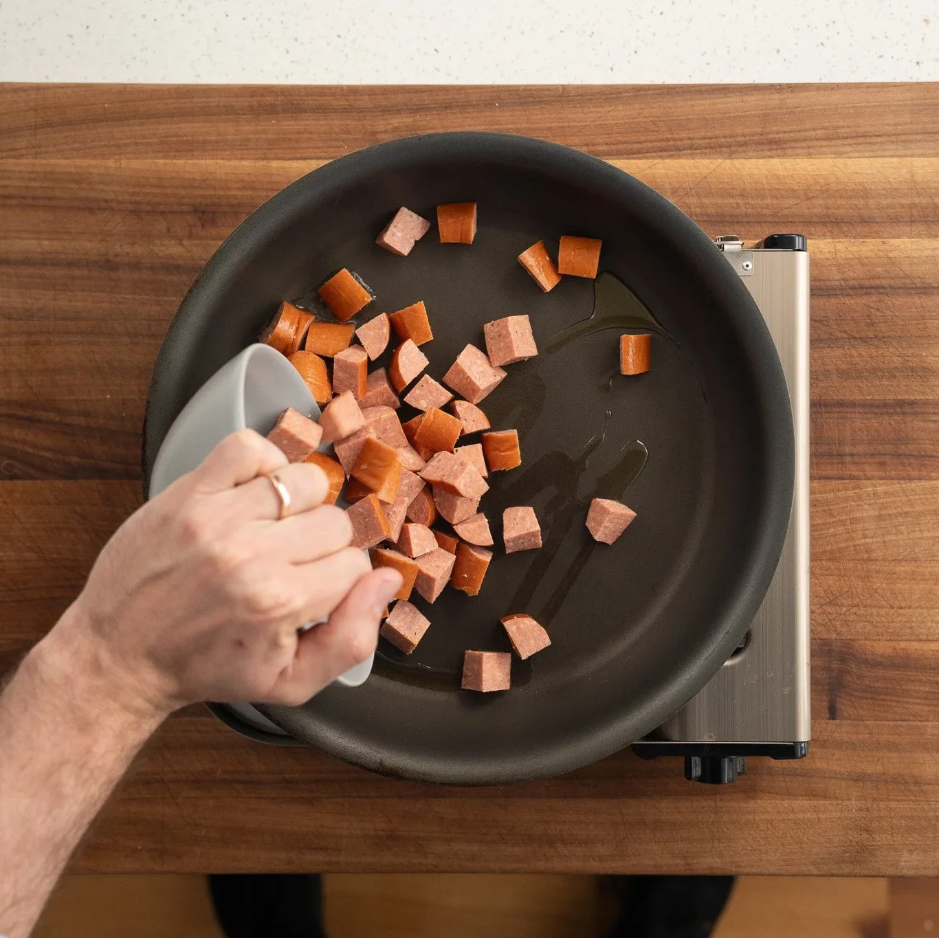 adding andouille sausage to a nonstick pan