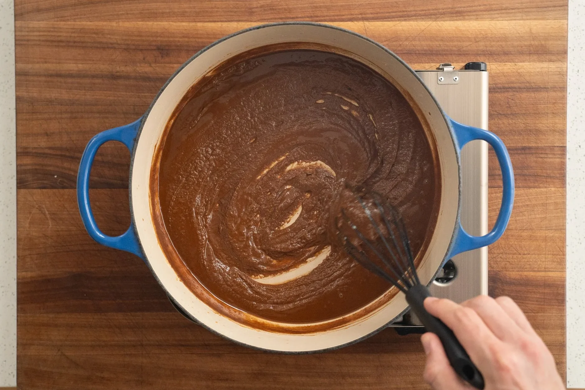 whisking deep brown roux in blue dutch oven