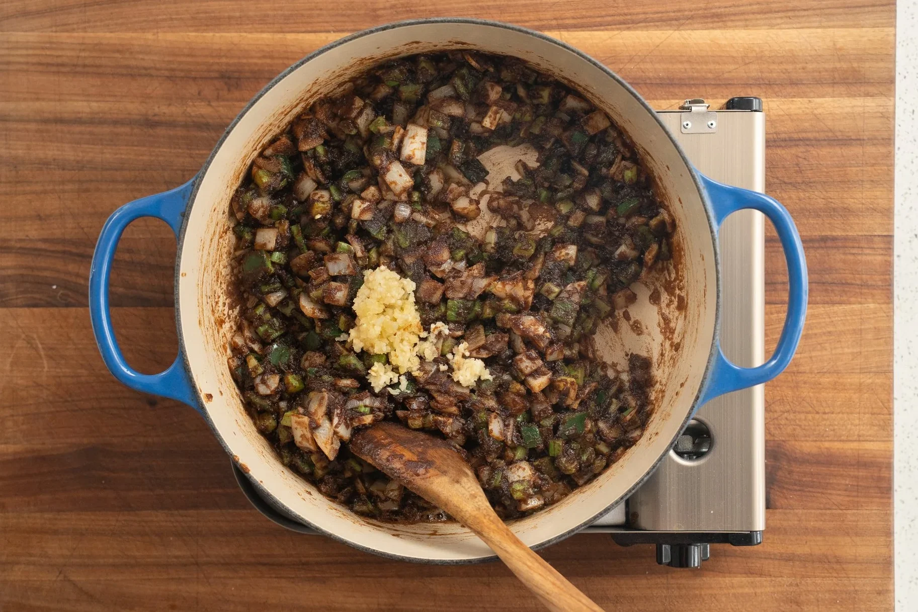 adding garlic into gumbo trinity and roux