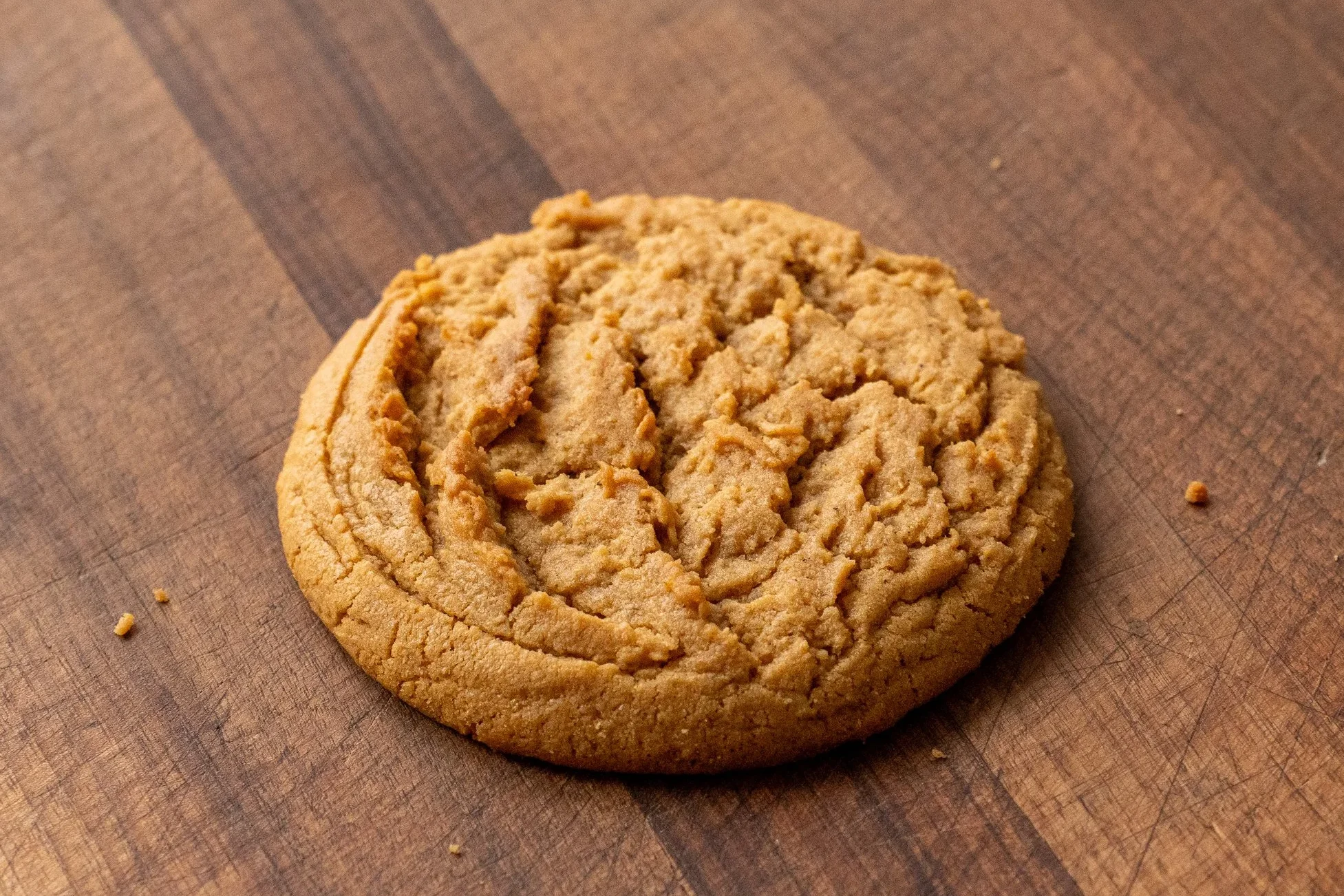 perfectly baked peanut butter cookie on wooden cutting board