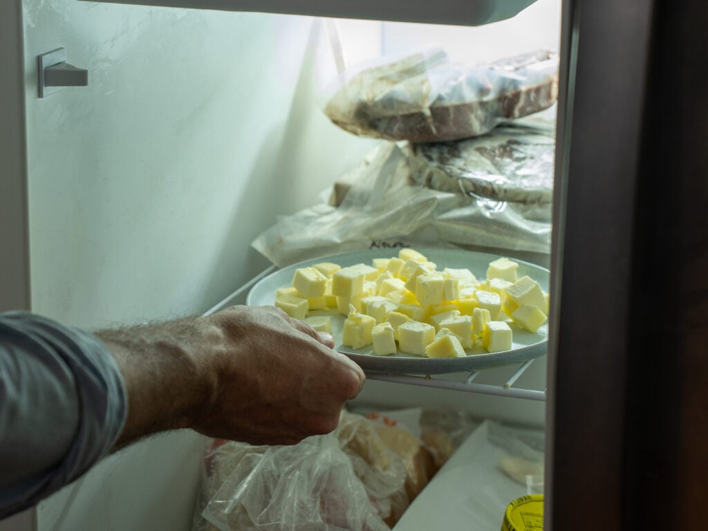 placing grey plate of cubed butter into freezer