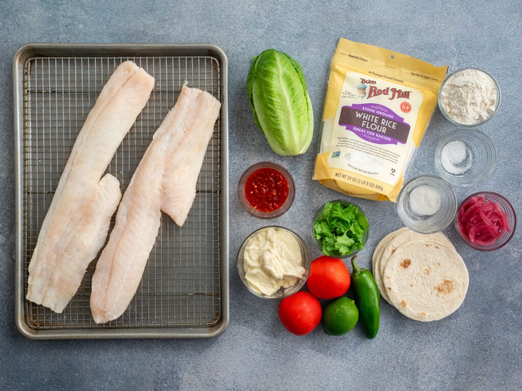 ingredients to make Baja Fish tacos arranged on grey background