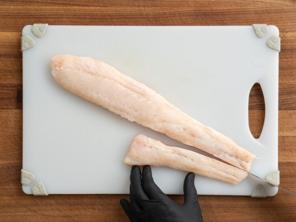 filets of Atlantic cod on plastic cutting board