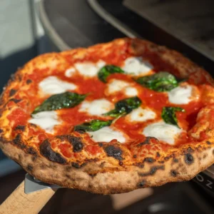 neapolitan pizza being pulled from pizza oven