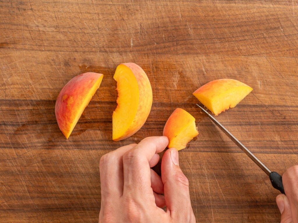 cutting peaches on wooden cutting board