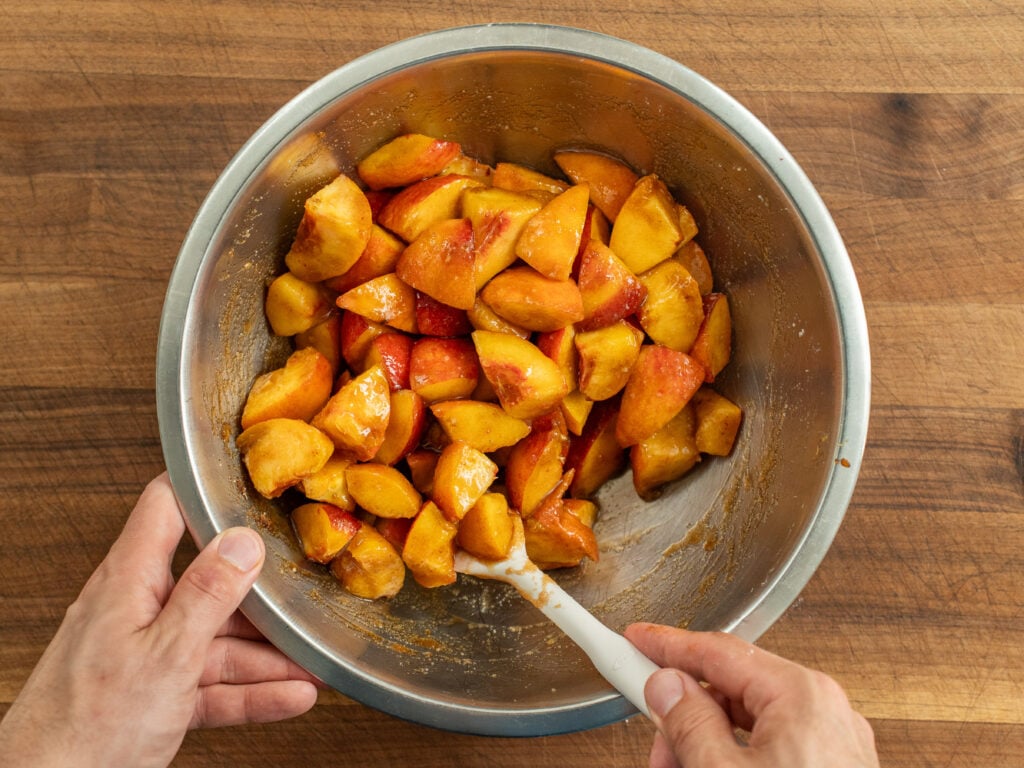 stirring cut peaches in bowl