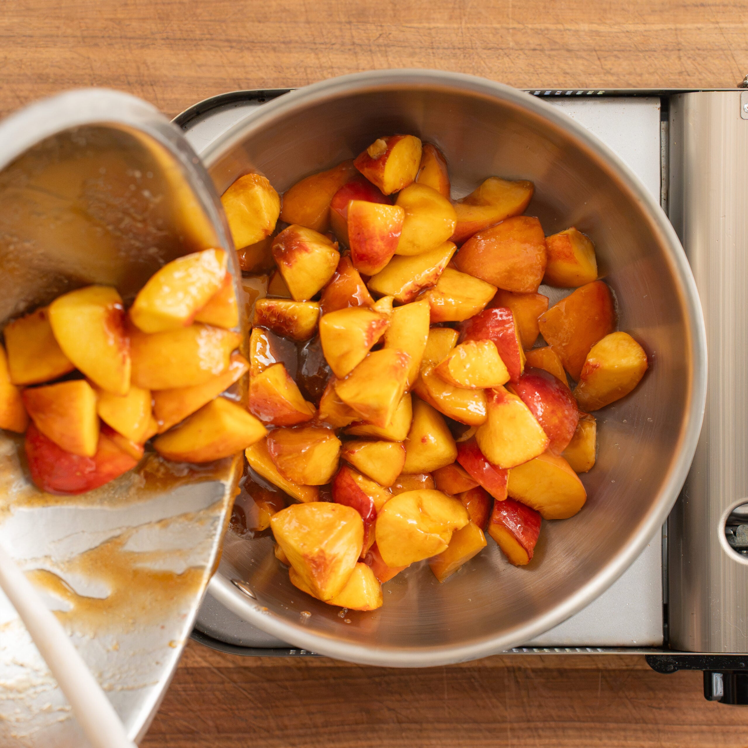 pouring peaches into silver sauce pan
