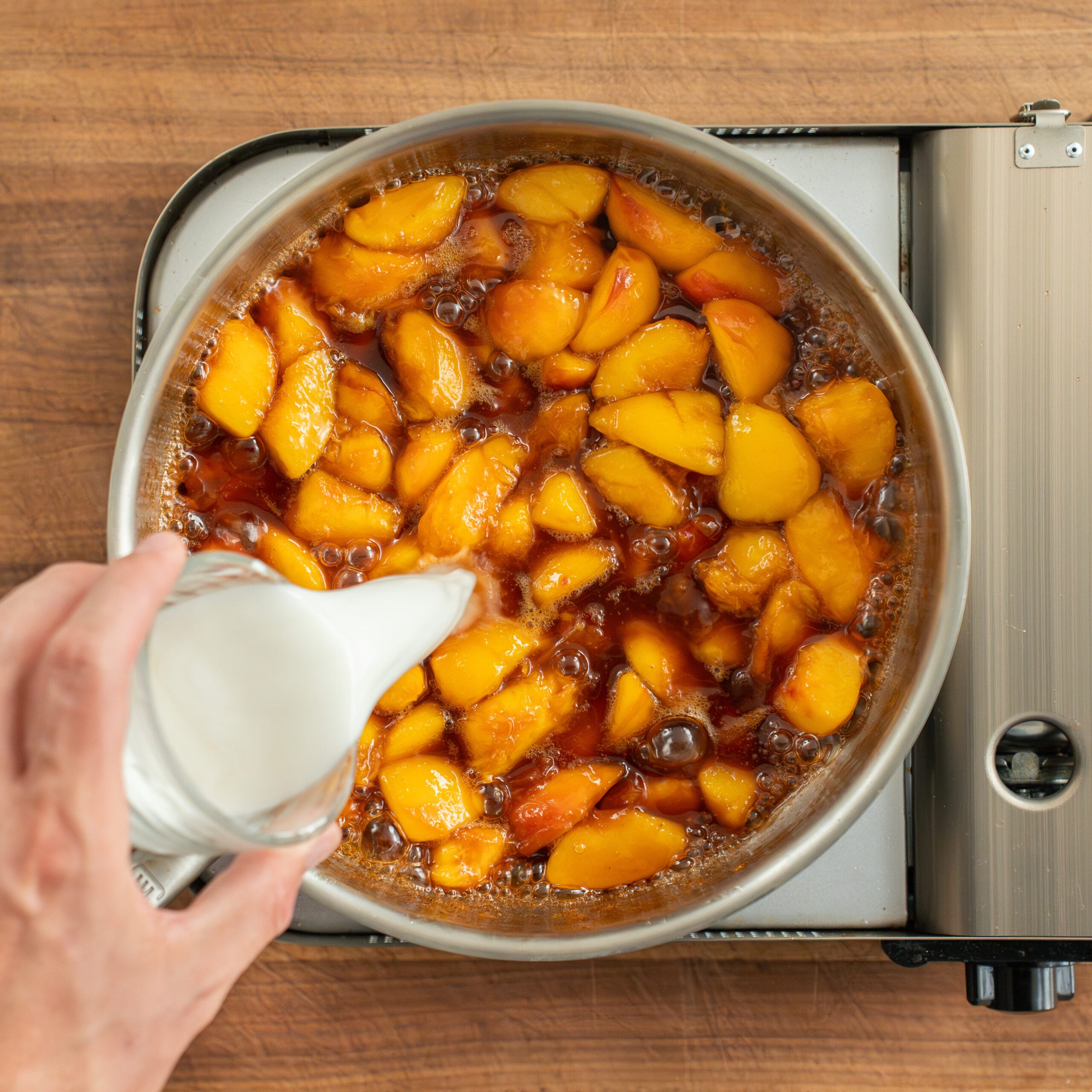 pouring cornstarch slurry into peach filling