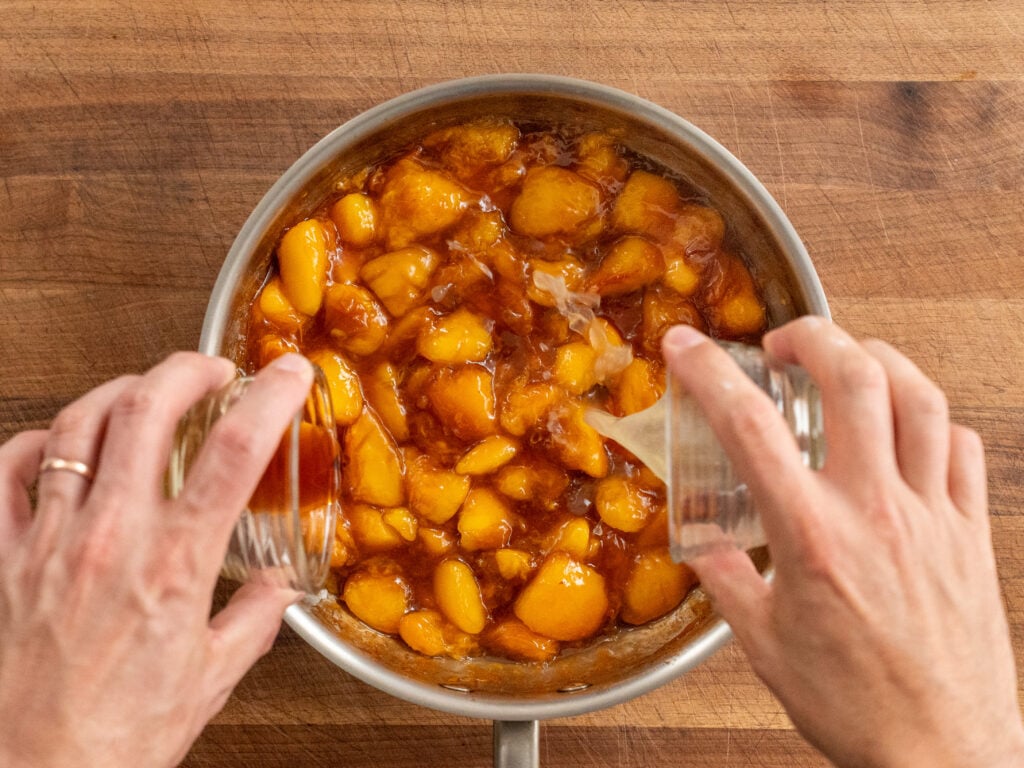 adding vanilla extract and lemon juice to cooked peach filling