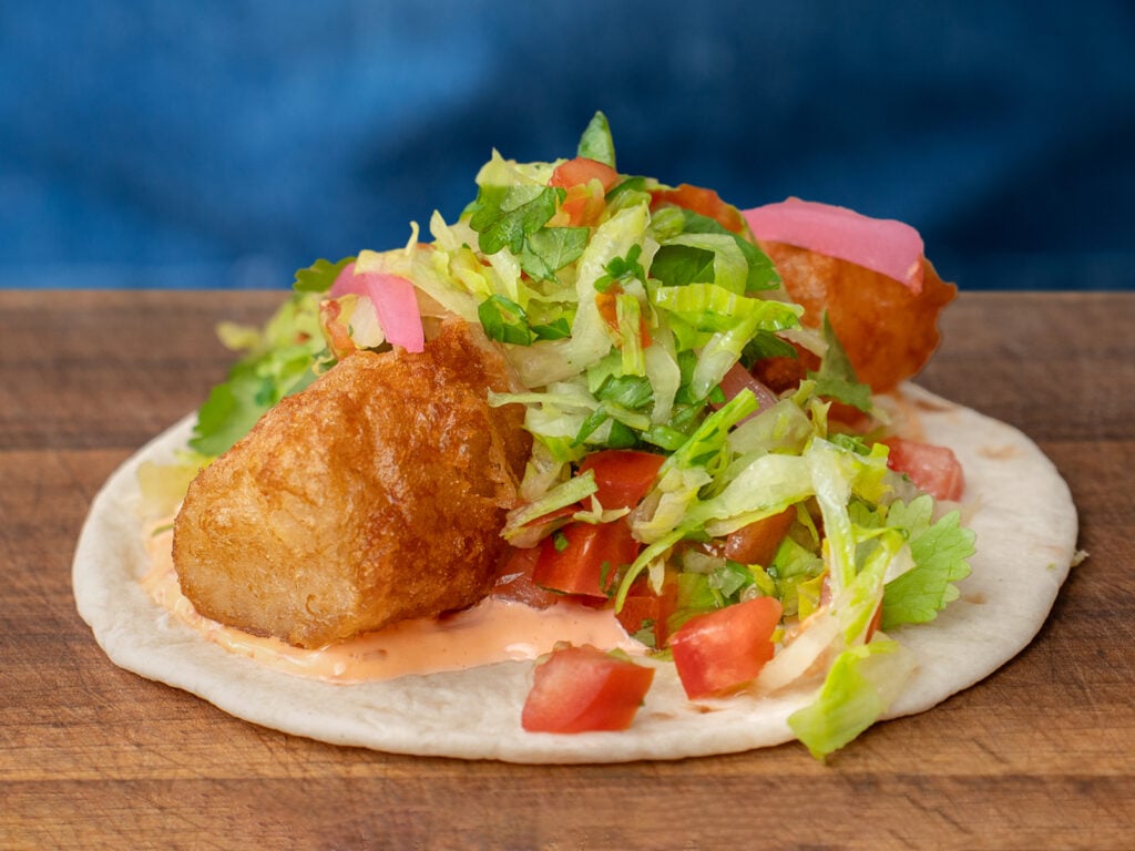 beer battered fish on tortilla with lettuce tomato pickled red onion