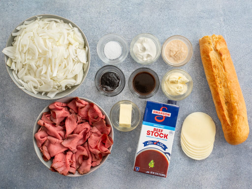 ingredients to make French dip sandwiches displayed on grey background