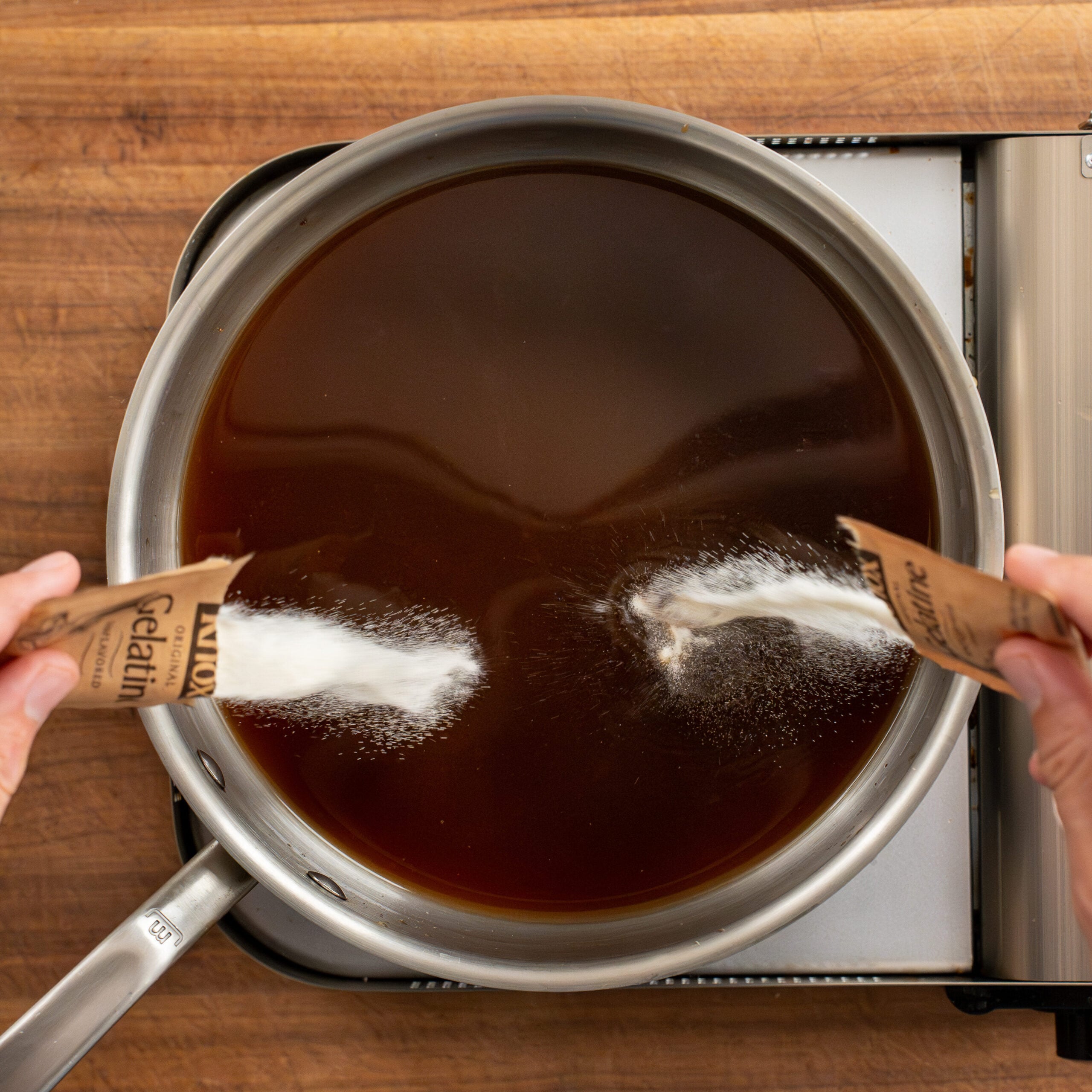 adding contents of 2 gelatin packets into beef stock