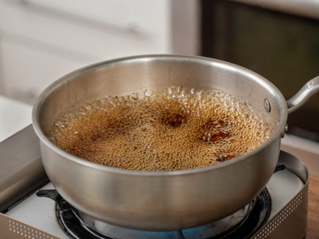 beef jus simmering in silver saucier