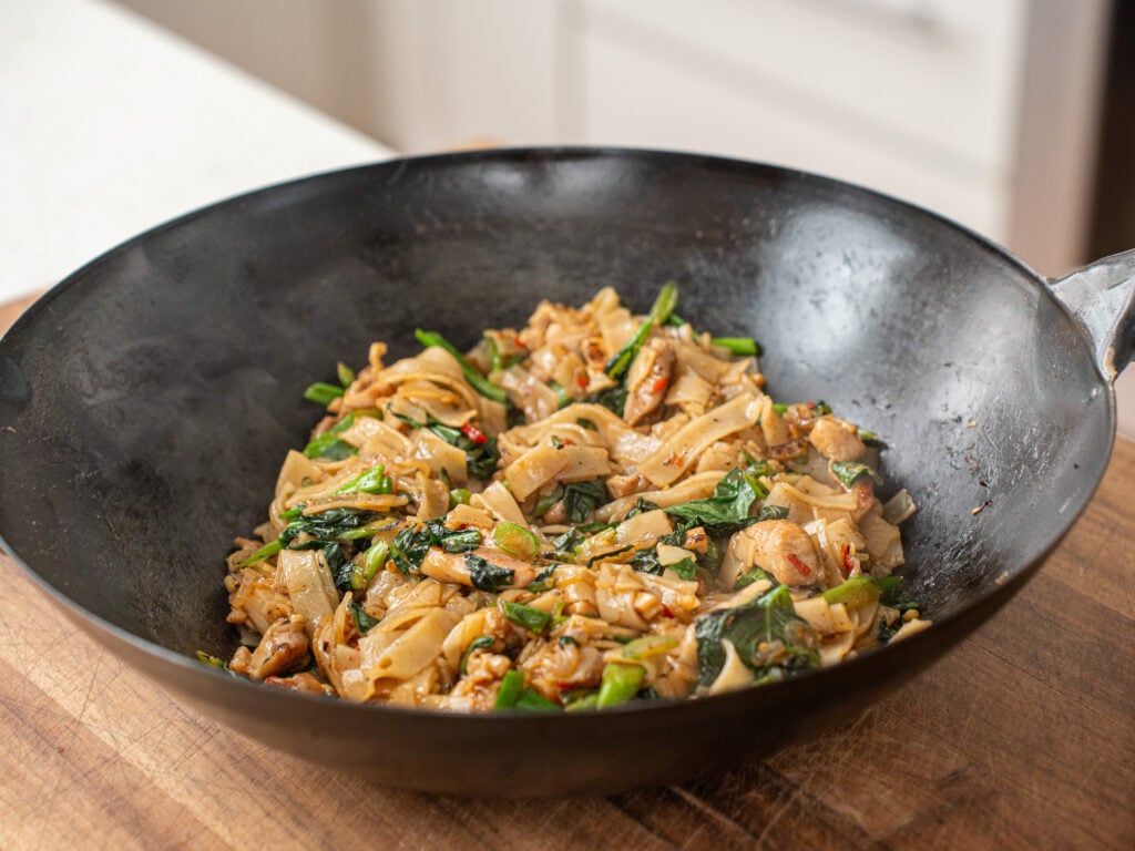 finished bowl of drunken noodles in wok