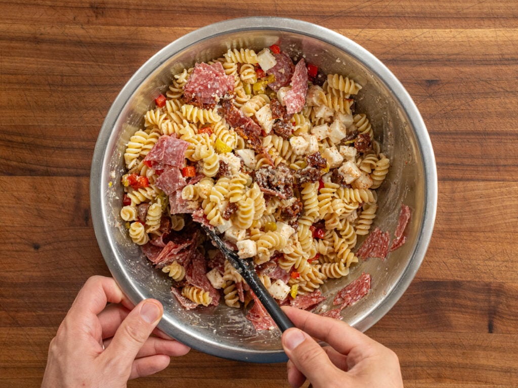 mixing pasta salad ingredients together